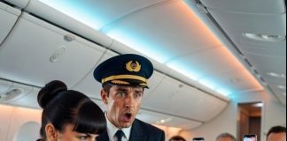 Kabina leta 808 kompanije Apex Airlines svetlucala je pod mekim zlatnim osvetljenjem dok je presecala noćno nebo od Njujorka do Los Anđelesa — najelitnija ruta na nebu. Ovde je sve imalo svoju cenu: tišina, udobnost, čak i poštovanje. Prva klasa nije bila samo kabina. Bila je to deklaracija moći. I Serena Blake je to dobro znala. Sa dvadeset šest godina, nosila je samopouzdanje poput svoje savršeno skrojene uniforme — plava kosa besprekorno zakačena, nokti besprekorni, osmeh izoštren godinama služenja ultra-bogatima. Nije bila samo stjuardesa. Bila je kustoskinja privilegija, nema sutkinja koja je pripadala ovom vazdušnom kraljevstvu. Sipanje starog Dom Pérignona milijarderima i ignorisanje svih ispod njihovog statusa činilo ju je nedodirljivom. Do danas. Prolaz se utišao dok je jedna starija žena polako zakoračila u prvu klasu. Delovala je van mesta na svaki mogući način — izbledeli sivi kardigan, široka cvetna haljina koja je videla bolje decenije, izgazene ortopedske cipele i iznošena platnena torba stisnuta čvrsto u rukama. Razgovori su utihnuli. Pogledi su je pratili kao da je greška koja se provukla pored obezbeđenja.